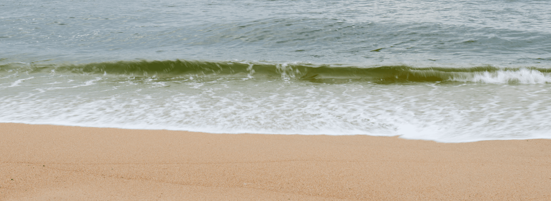 Gentle waves lapping at a sandy beach.